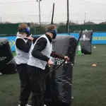 Archery tag — hráči s lukmi a maskami