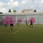 Hráči v nafukovacích bublinách počas zápasu