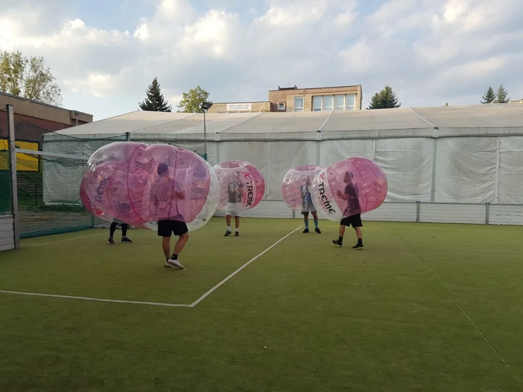 Hráči v nafukovacích bublinách počas zápasu